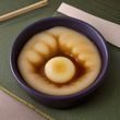 品控专员在检验台前检查最小比基尼绑带缝线工艺，手持放大镜细看